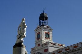 La Mariblanca as if impatient in front of the reloj de Losada en la Puerta del Sol. "Lorem ipsum dolor sit amet, consectetur adipiscing elit, sed do eiusmod tempor incididunt ut labore et dolore magna aliqua. Ut enim ad minim veniam, quis nostrud exercitation ullamco laboris nisi ut aliquip ex ea commodo consequat. Duis aute irure dolor in reprehenderit in voluptate velit esse cillum dolore eu fugiat nulla pariatur. Excepteur sint occaecat cupidatat non proident, sunt in culpa qui officia deserunt mollit anim id est laborum."
