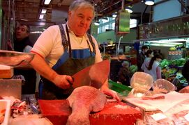 Cutting a slice of grouper in the Mercado de la Cebada.